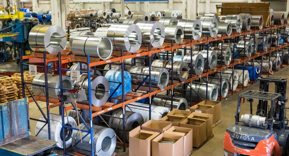 Lean manufacturing facility with metal coils, storage racks and a forklift