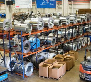 Lean manufacturing facility with metal coils, storage racks and a forklift