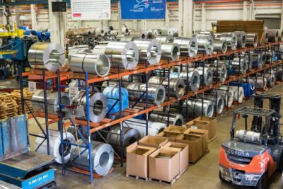Lean manufacturing facility with metal coils, storage racks and a forklift