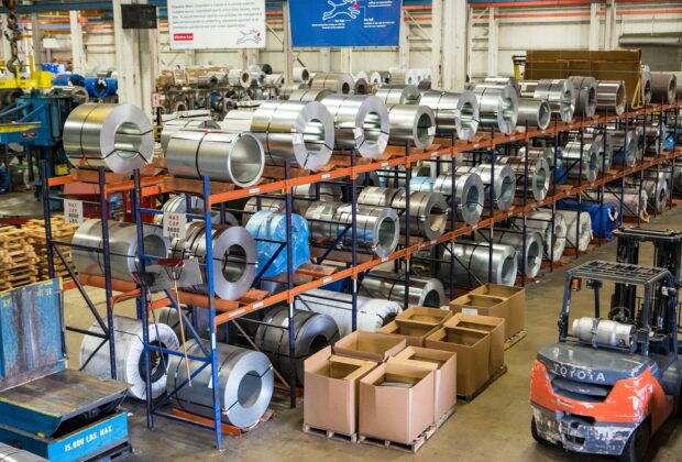 Lean manufacturing facility with metal coils, storage racks and a forklift